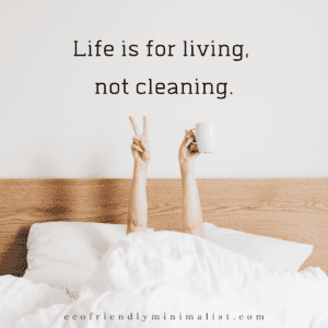 Two hands rising from white linen sheets.  One hand has a peace sign.  The other hand holds a coffee cup.  words:  Life is for living, not cleaning.